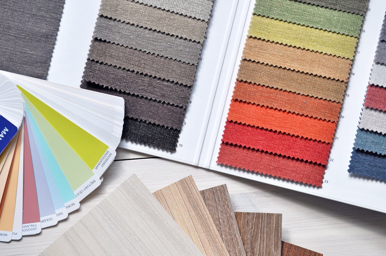 our-story-01 Colorful fabric and paint swatches laid out for design inspiration and material selection.